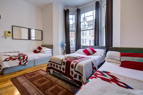 um quarto de hotel com duas camas e uma janela em London Residence Hotel em Londres