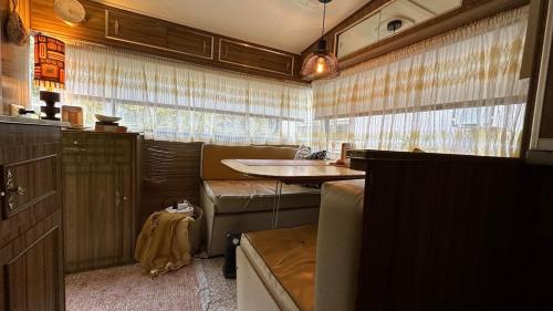 a rv with a couch and a table in it at Australian Retro Beach stay in Rye