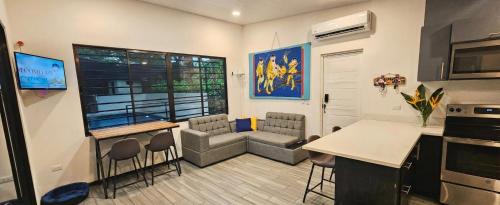 Una cocina y una sala de estar con mesa y sillas. en Pura Vida - Villa Elenita, en Parrita