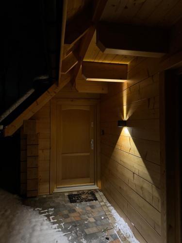 a wooden door in a room with a wall at Domki Michelle in Wisła