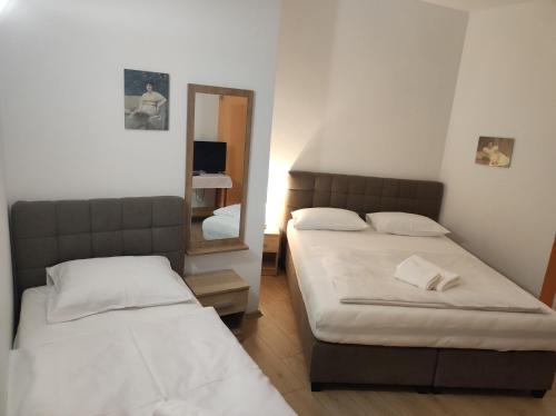 a bedroom with two beds and a mirror at Rooms San in Velika Gorica