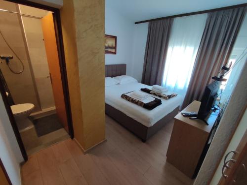 a hotel room with a bed and a bathroom at Rooms San in Velika Gorica