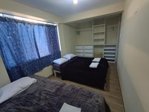 Una pequeña habitación con dos camas y una ventana. en DEPPIu, en Piura