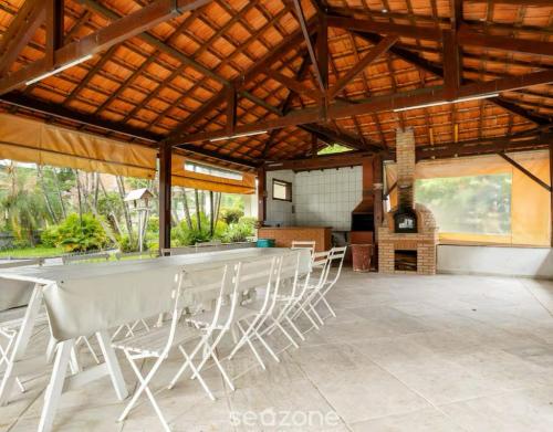 stół i krzesła siedzące pod drewnianym dachem w obiekcie Apartamento 122 no Condomínio Quisisana w mieście Poços de Caldas