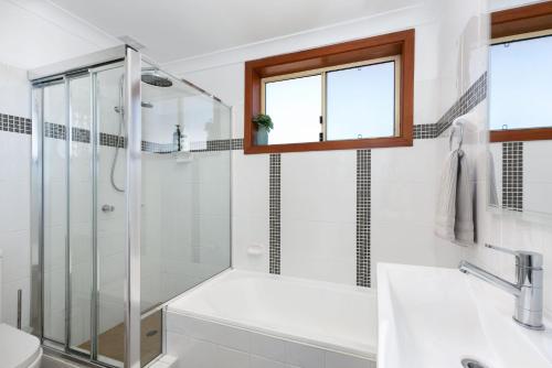 ein weißes Badezimmer mit Dusche und Waschbecken in der Unterkunft Beachside Nook at Warilla in Lake Illawarra