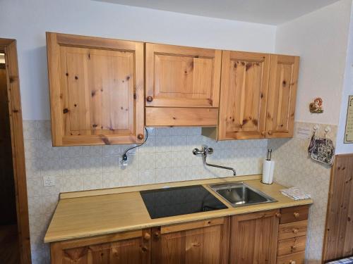 a kitchen with wooden cabinets and a sink at Le Grenier Morgex La Ruine in Morgex