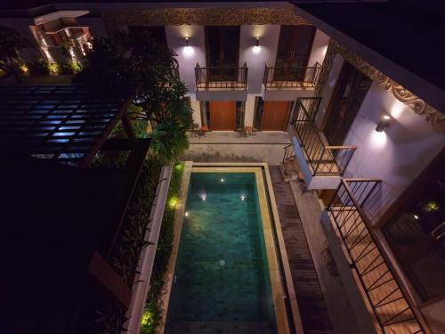 Una vista aérea de una piscina en un edificio por la noche. en Mahesa Seminyak, en Seminyak