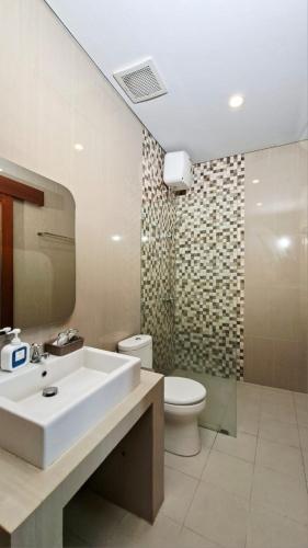 a bathroom with a sink and a toilet at Mahesa Seminyak in Seminyak