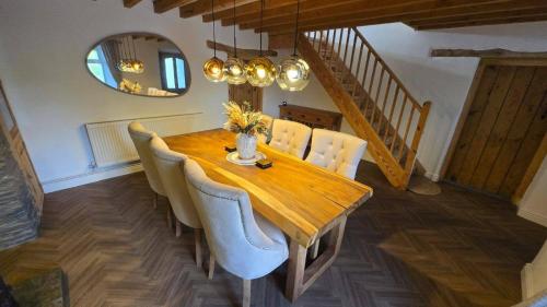 Un comedor con mesa y sillas de madera. en Cwm Uchaf Holiday Home, hot tub and horse view!, en Abergele