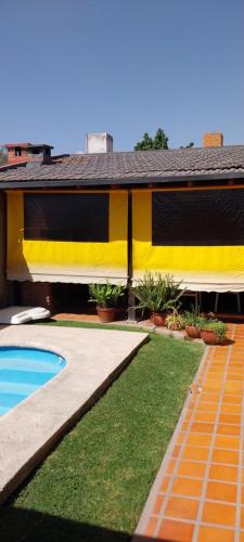 ein gelbes Haus mit Pool und Hof in der Unterkunft La Emilia Casa de Vacaciones con Pileta y Quincho in Salta