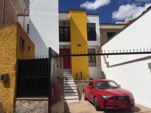 a red car parked in front of a house at Casa Dos Hermanas in Guanajuato