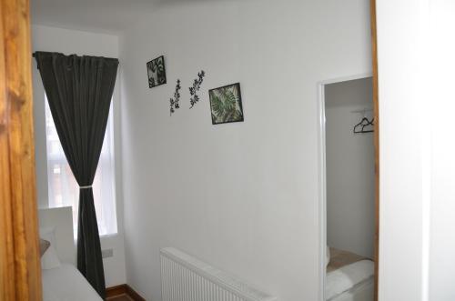 a room with a curtain and a mirror at JMG HOUSE - Quality Rooms in West Bromwich