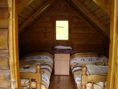una camera con tre letti in una baita di tronchi di Eko Katun Damjanovic - Bjelasica a Mojkovac