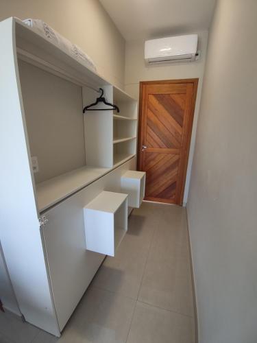 a walk in closet with a door and shelves at Pousada Solari in São Francisco do Sul