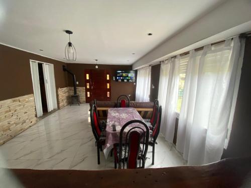 ein Esszimmer mit einem Tisch, Stühlen und Vorhängen in der Unterkunft Florencia in Miramar