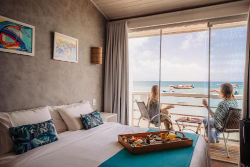 a hotel room with a bed with a tray of fruit on it at Bamboo Búzios Hostel in Búzios