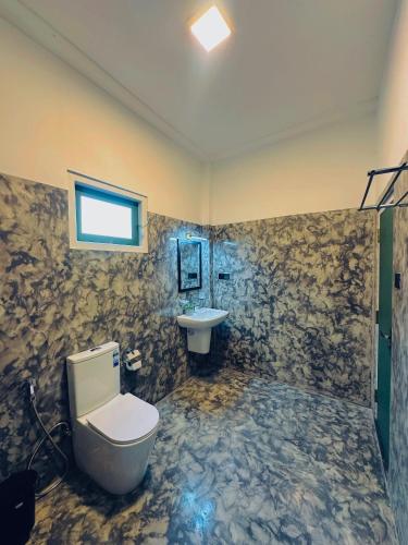a bathroom with a toilet and a sink at Villa Vows in Tangalle