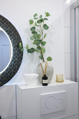 a vase with a plant on a white cabinet at Arden Stay Apartments in Duisburg