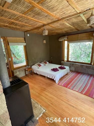 a bedroom with a bed and a flat screen tv at Descansa al pie del champaqui escuchando el arroyo in San Javier
