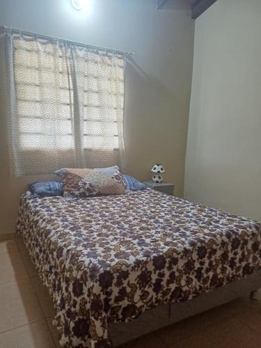 a bedroom with a bed with a comforter on it at De vuelta a casa in Zarate Isla