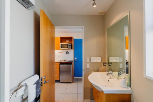baño con lavabo y cocina en Sumner Bay Motel, en Christchurch