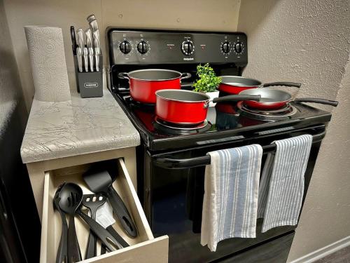a kitchen with three pots and pans on a stove at KINGbed A plus location A plus for workers LongStayDiscount in Sherman