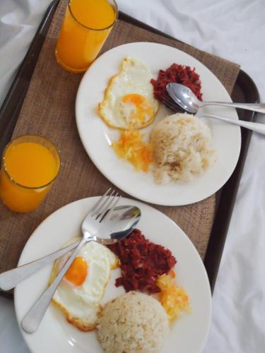 twee borden met eten met eieren en rijst op een dienblad bij Sacaan Tropical Breeze Resort in Sogod
