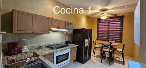 una cucina con frigorifero nero e tavolo di Departamentos Residenciales a Ciudad Madero