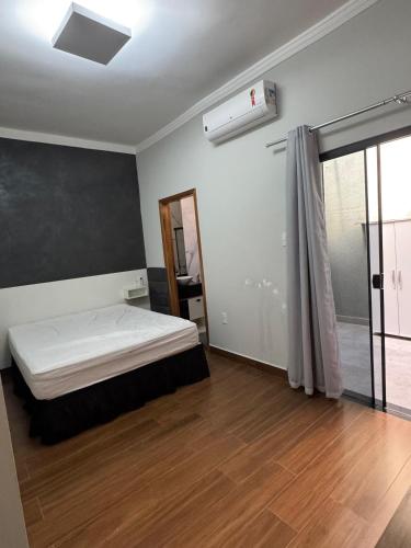 a bedroom with a bed and a air conditioner at Casa Encanto in Franca