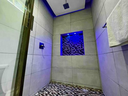 a bathroom with a shower with blue lights in it at Spectacular Private House in Playa del Carmen