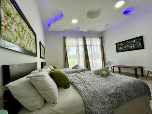 a bedroom with two beds and a tv on the ceiling at Spectacular Private House in Playa del Carmen