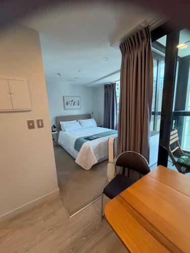 a bedroom with a bed and a table and a chair at Central City Prime-next to SKY in Auckland