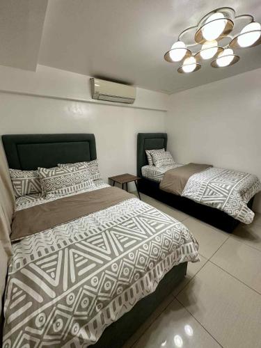 a bedroom with two beds and a ceiling at Shell Residence 2 bedroom by Kathy in Manila