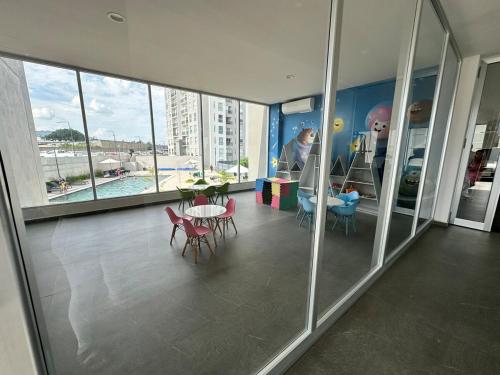 Moderno Departamento Stelar Bugambilias في غواذالاخارا: غرفة مع طاولة وكراسي في مبنى