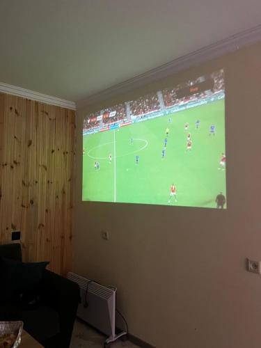 uno schermo di proiezione di una partita di calcio su una parete di Gamma house a Balaovit