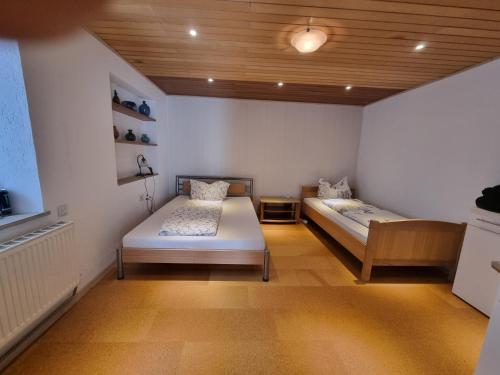 a bedroom with two beds and a wooden ceiling at Ferienwohnung-La Casa in Heidenheim