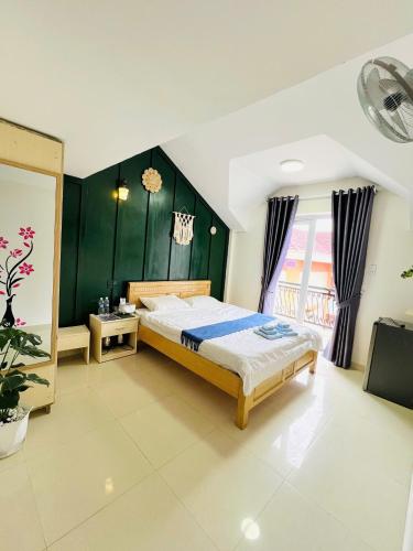 una camera da letto con un letto e una parete verde di Rin Bon Home a Da Lat