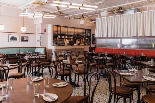 an empty dining room with tables and chairs at Kurrajong Hotel Sydney in Sydney
