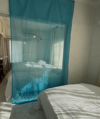 a bed with a blue canopy in a bedroom at 世田谷区経堂の小さな一棟貸wakusei in Tokyo
