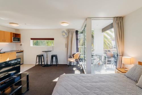 Un dormitorio con una cama y una cocina y una sala de estar. en Sumner Bay Motel, en Christchurch