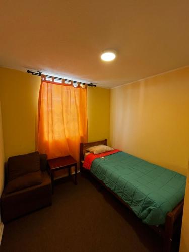 a bedroom with a bed and a chair and a window at Departamento 3 piezas in Viña del Mar