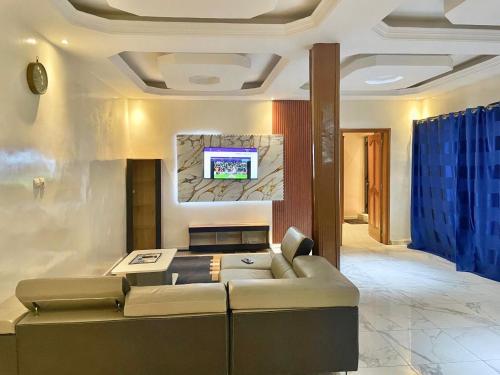 a living room with a couch and a tv on a wall at Apparemment meublé en face de la mer in Dakar