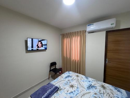a room with a bed and a tv on the wall at Sur Backpackers in Santa Cruz de la Sierra