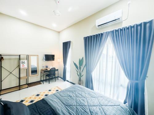 a bedroom with a bed and a window and a desk at The Canal Villa in Sungai Besar