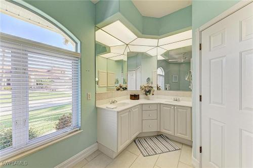 un bagno con due lavandini e uno specchio di Sunsets Waterfront Saltwater Heated Pool Retreat a Punta Gorda