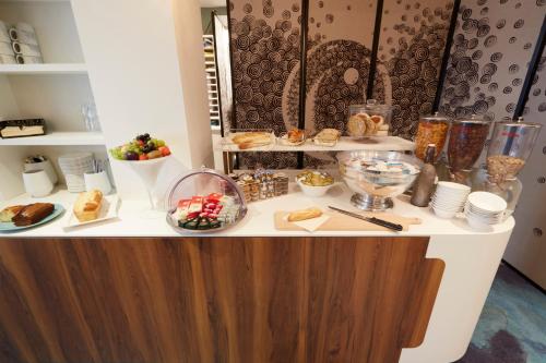 a buffet with bread and other food on a table at Hôtel Europe and Spa in Reims