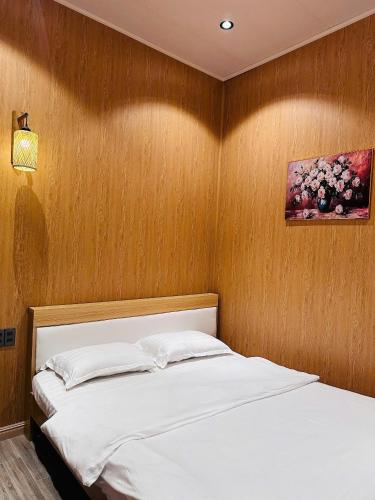 a bedroom with a bed and a painting on the wall at Giăng's House Farmstay & Glamping in Bảo Lộc