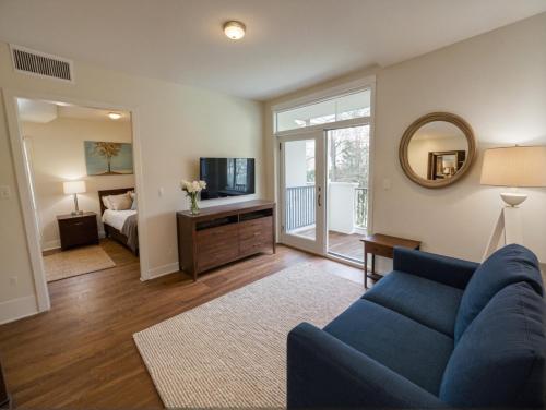 a living room with a blue couch and a bedroom at Glamorous KTown Boutique Residences with Rooftop view in Los Angeles