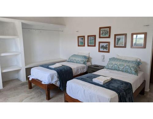 une chambre avec deux lits et une étagère dans l'établissement Villa Caracol - Hello Progreso, à San Benito