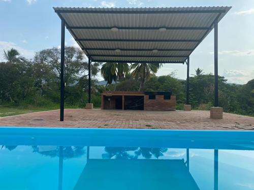 a building with a roof over a body of water at Finca El Balmoral in Tocaima
